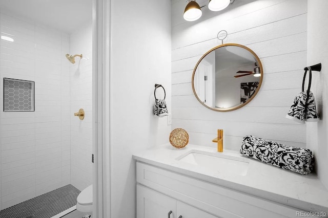 7651 Robb St, Arvada, CO 80005 - bathroom featuring vanity, a stall shower, ceiling fan, and wooden walls