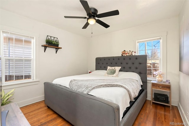 bedroom with wood finished floors, a ceiling fan, and baseboards