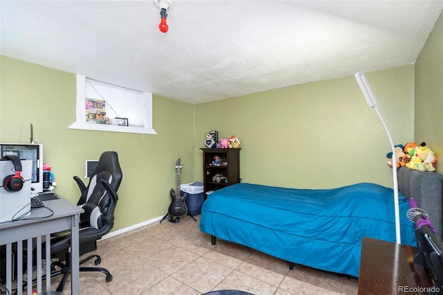 bedroom with tile patterned flooring, a textured ceiling, and baseboards