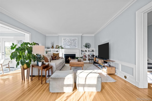 living room with light hardwood / wood-style floors and ornamental molding