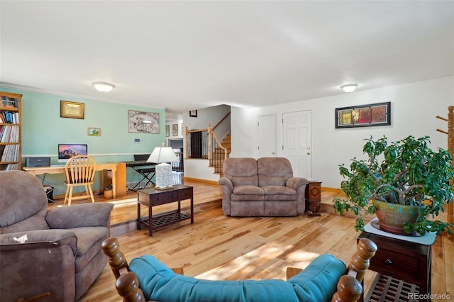 living room featuring stairs, baseboards, and wood finished floors