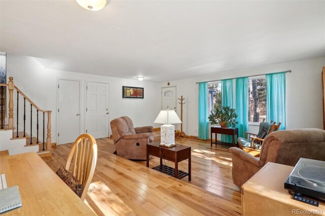 living area featuring light wood finished floors and stairs