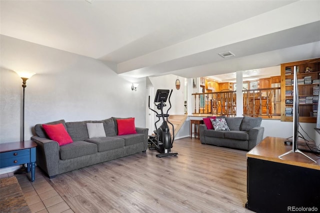 living area featuring visible vents and wood finished floors