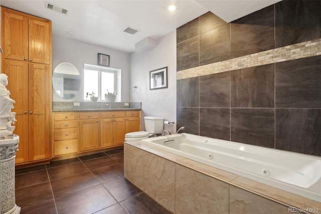 full bathroom featuring toilet, a tub with jets, tile patterned flooring, and visible vents