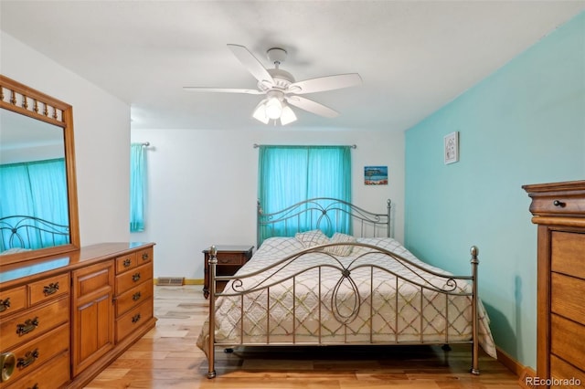 bedroom with baseboards, visible vents, ceiling fan, and light wood finished floors