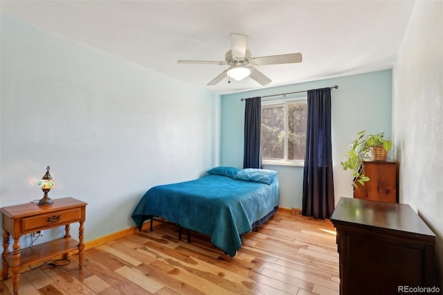 bedroom with ceiling fan, light wood-type flooring, and baseboards