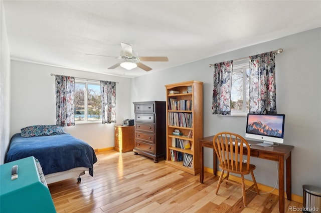 bedroom with a ceiling fan, light wood-type flooring, and baseboards