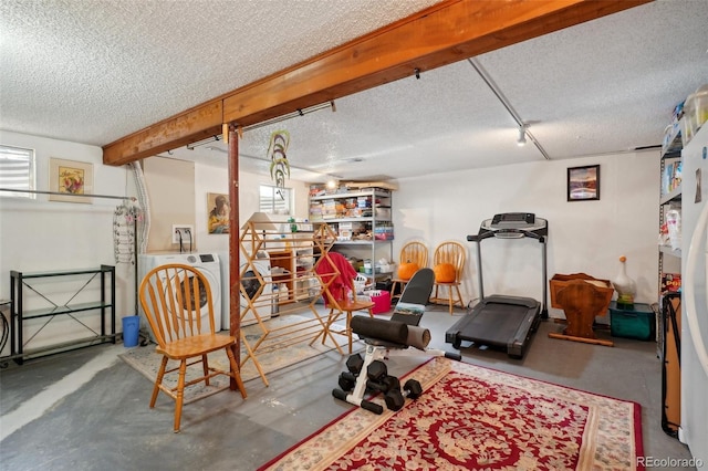 workout area with washer / dryer and a textured ceiling