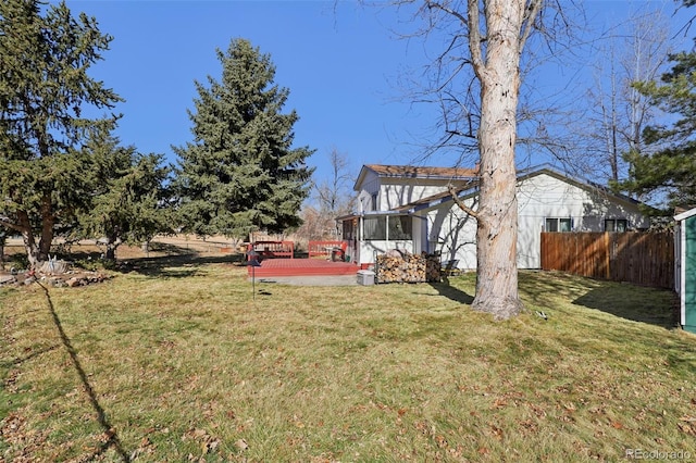 view of yard with a sunroom and fence