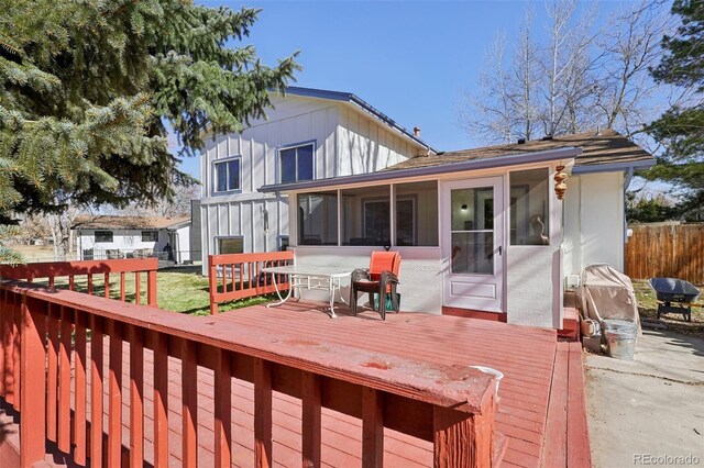 wooden deck with fence and a sunroom