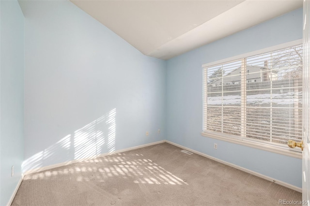 carpeted spare room featuring vaulted ceiling