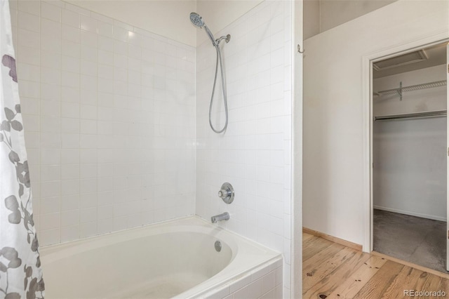 bathroom with wood-type flooring and shower / bathtub combination with curtain