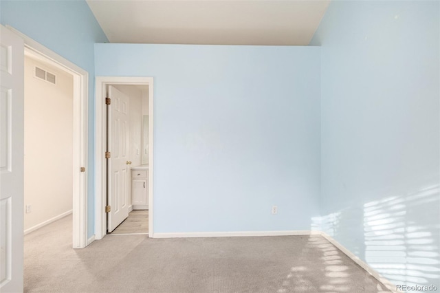 spare room with vaulted ceiling and light carpet