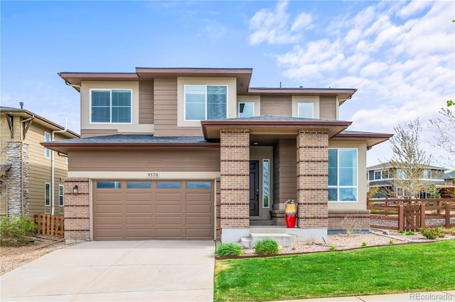 prairie-style house with an attached garage, fence, brick siding, and concrete driveway