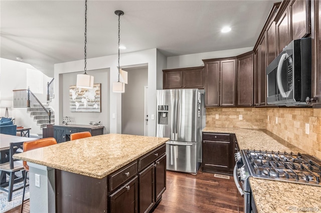 kitchen featuring decorative backsplash, dark brown cabinets, dark wood-style floors, light stone counters, and stainless steel appliances