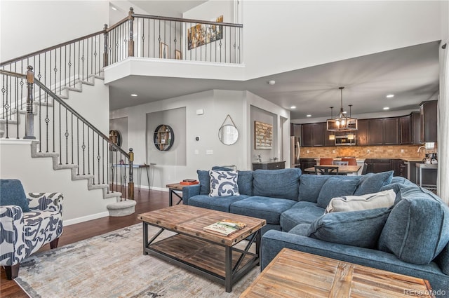 living room with stairs, recessed lighting, baseboards, and wood finished floors