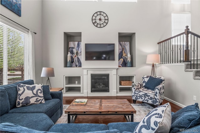 living area featuring baseboards, wood finished floors, and a wealth of natural light