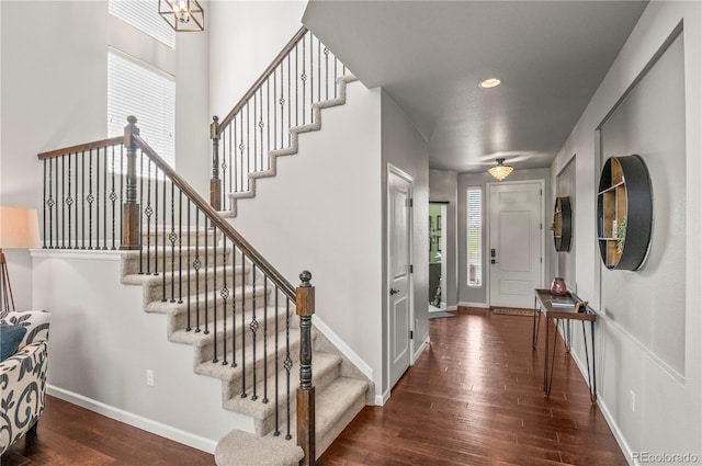 foyer featuring baseboards, hardwood / wood-style flooring, and stairway