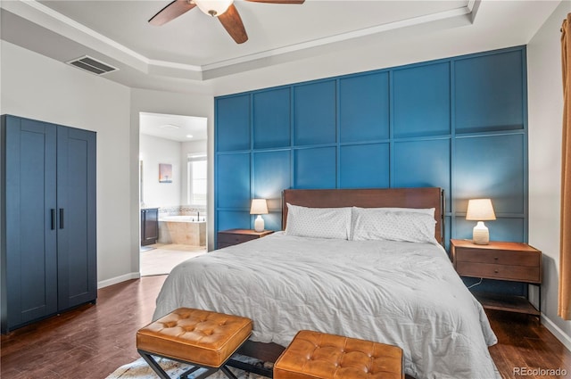 bedroom with a raised ceiling, baseboards, dark wood-style floors, and visible vents