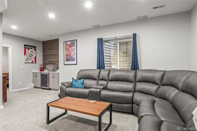 carpeted living area featuring visible vents, wine cooler, baseboards, recessed lighting, and a bar