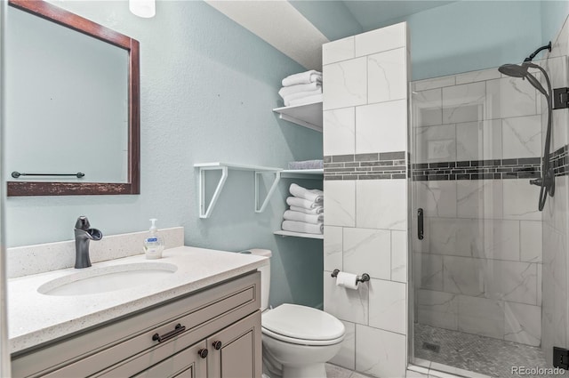 full bathroom featuring toilet, a shower stall, and vanity