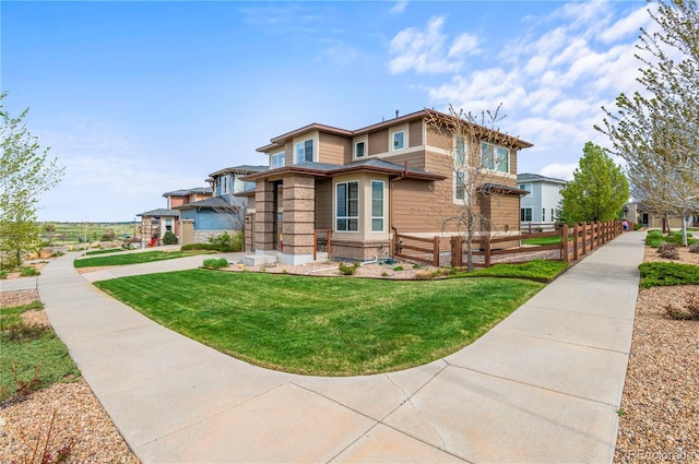view of front of house with brick siding, fence, and a front yard