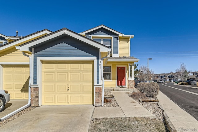 view of front of house featuring stone siding, driveway, and an attached garage