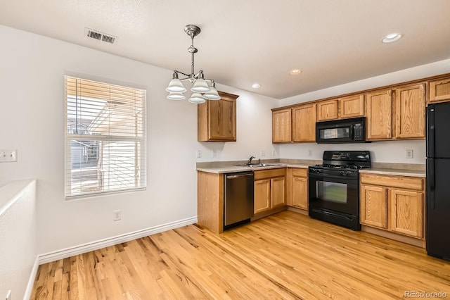 kitchen with black appliances, light countertops, visible vents, and a sink