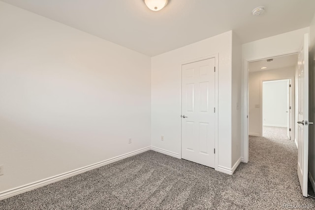 unfurnished bedroom featuring baseboards and carpet