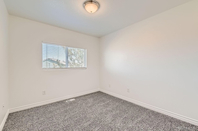 carpeted spare room featuring visible vents and baseboards