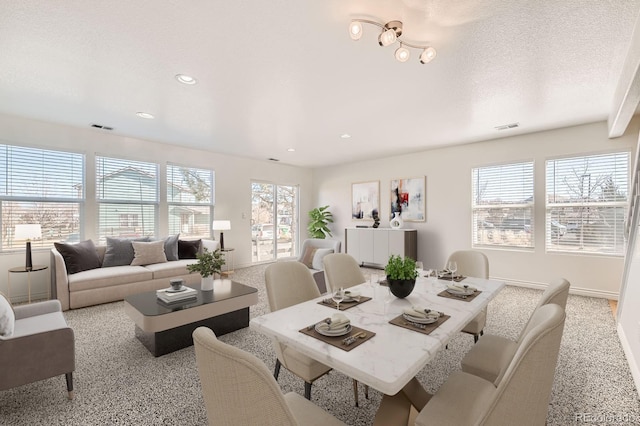 dining room with a healthy amount of sunlight, visible vents, and a textured ceiling