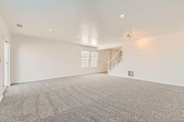 carpeted empty room featuring stairway, recessed lighting, baseboards, and visible vents