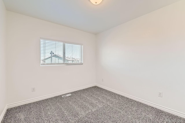 carpeted empty room featuring visible vents and baseboards