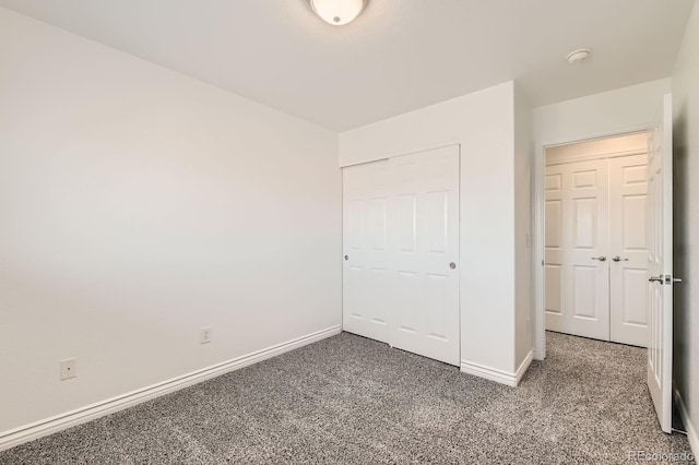 unfurnished bedroom with carpet, baseboards, and a closet