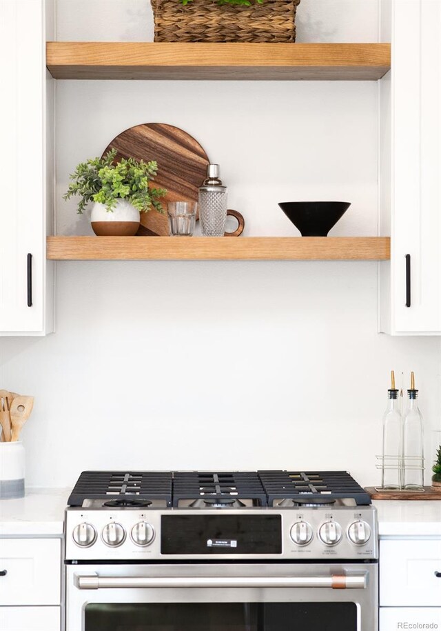 230 E Ellsworth Ave, Denver, CO 80209 - kitchen featuring gas stove, open shelves, white cabinets, and light countertops