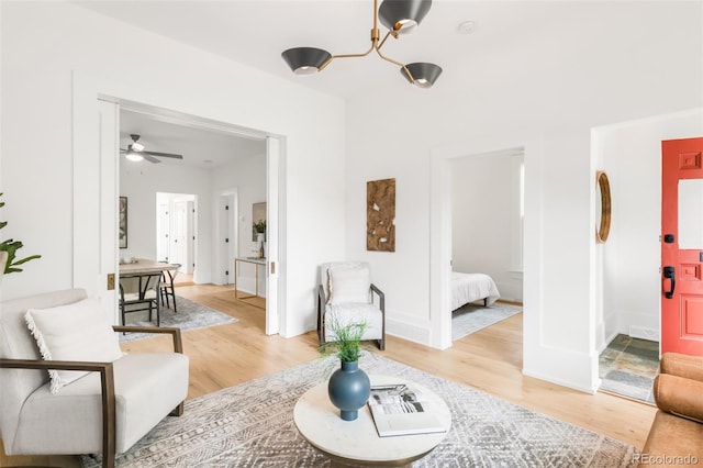 230 E Ellsworth Ave, Denver, CO 80209 - living area featuring light wood-type flooring, a chandelier, and a ceiling fan