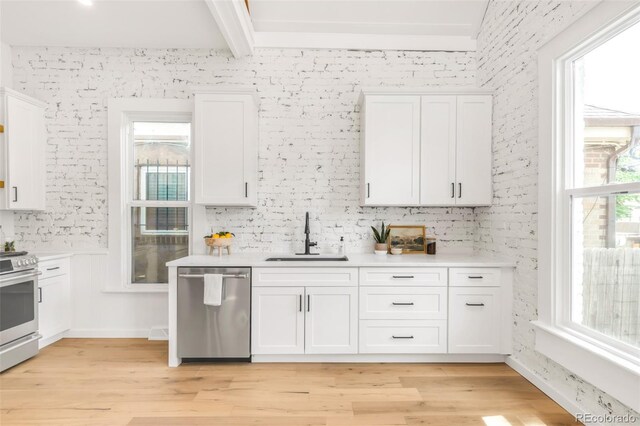 230 E Ellsworth Ave, Denver, CO 80209 - kitchen with stainless steel appliances, a sink, white cabinets, light countertops, and beam ceiling