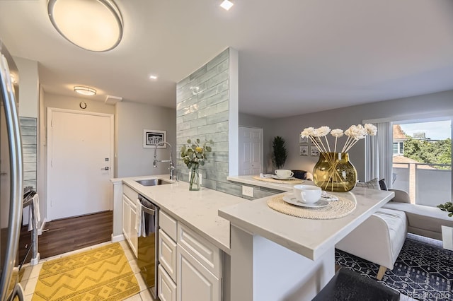 937 N Clarkson St Unit 405, Denver, CO 80218 - kitchen with stainless steel appliances, white cabinetry, and light stone countertops