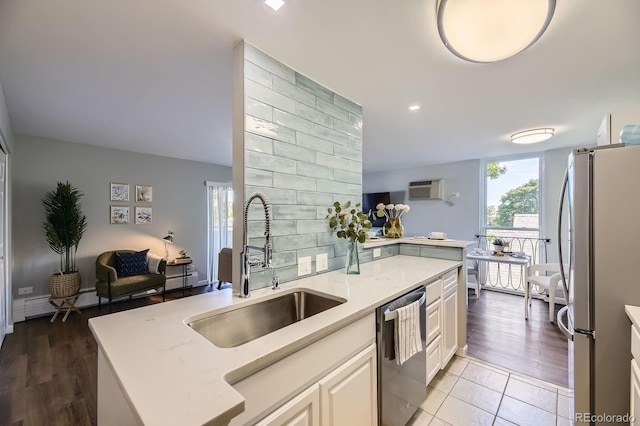 937 N Clarkson St Unit 405, Denver, CO 80218 - kitchen featuring stainless steel appliances, a wall unit AC, open floor plan, white cabinetry, and light wood-type flooring