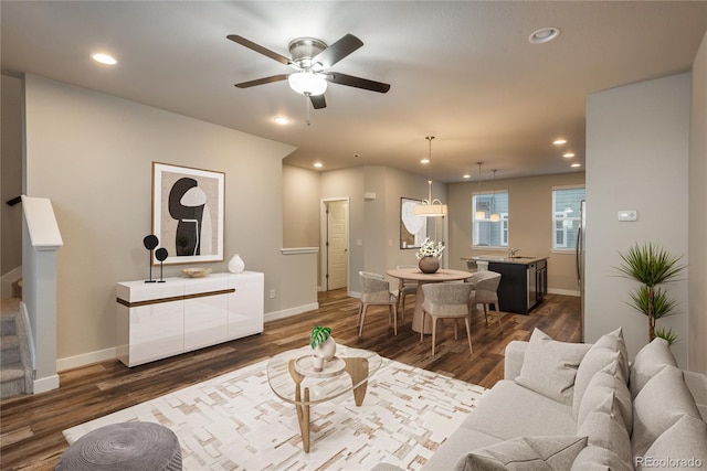 living room featuring dark hardwood / wood-style floors, ceiling fan, and sink