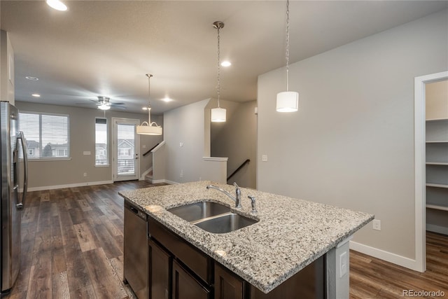 kitchen with sink, decorative light fixtures, dark brown cabinets, an island with sink, and stainless steel appliances