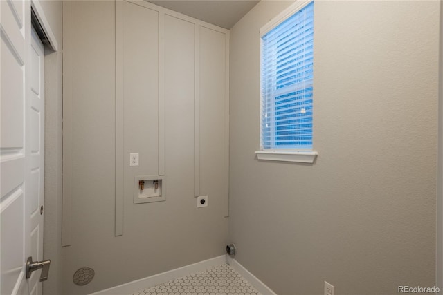 clothes washing area featuring electric dryer hookup, light tile patterned floors, and hookup for a washing machine