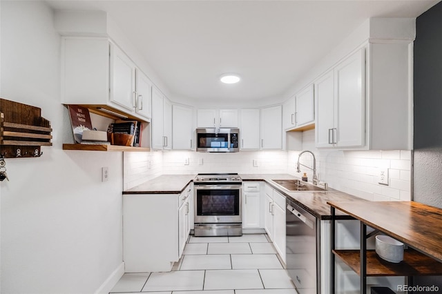 20 S Logan St Unit 104, Denver, CO 80209 - kitchen featuring stainless steel appliances, a sink, open shelves, and backsplash