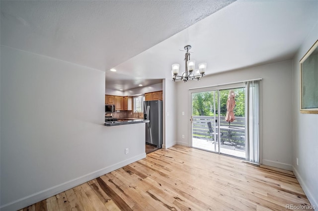 kitchen featuring stainless steel appliances, a chandelier, light wood-type flooring, baseboards, and recessed lighting