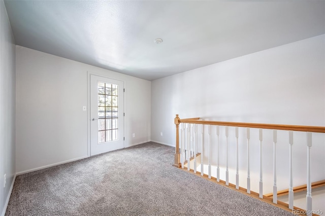 carpeted empty room with baseboards