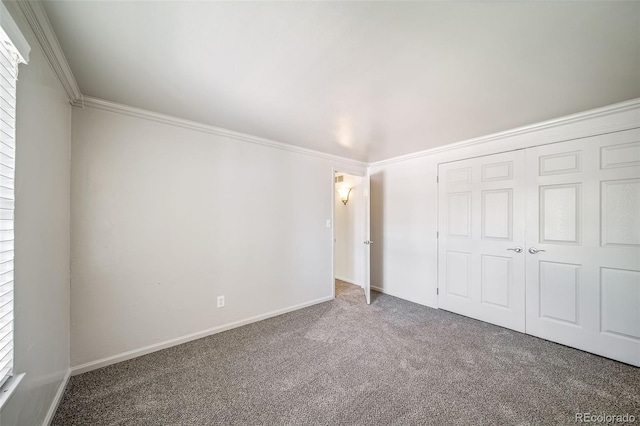 unfurnished bedroom with carpet flooring, ornamental molding, a closet, and baseboards