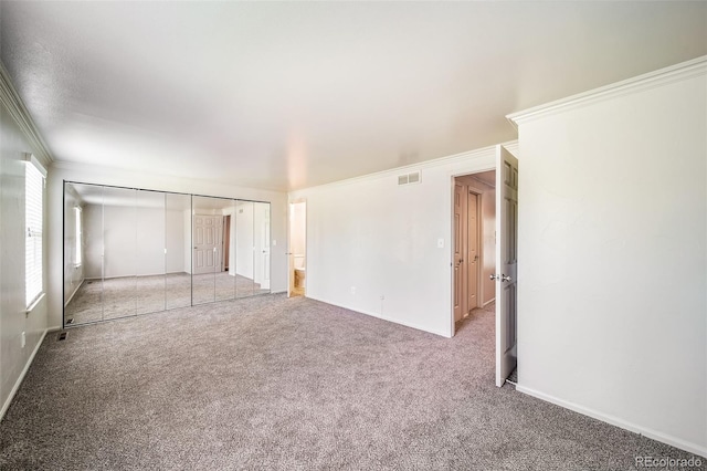 unfurnished bedroom with crown molding, light colored carpet, and baseboards
