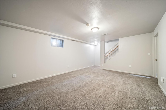 finished basement with baseboards, carpet floors, stairway, and a textured ceiling