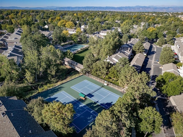 aerial view of property's location with nearby suburban area and a heavily wooded area