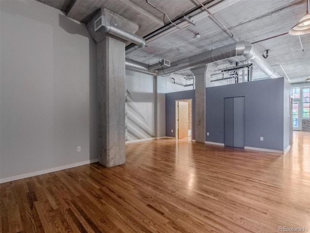 spare room featuring baseboards and wood finished floors